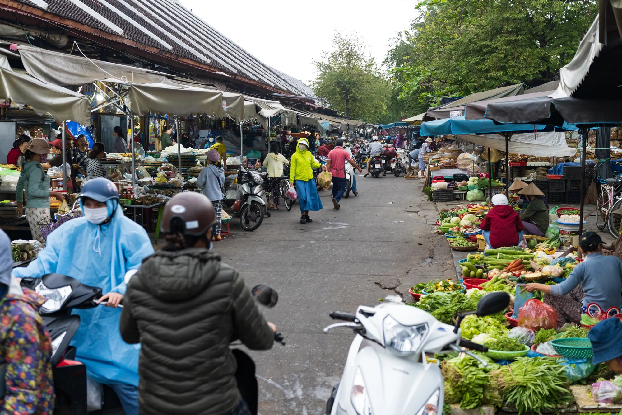 市場の様子。道の両側に店が並んでいて、地面や机に青果が並んでいる