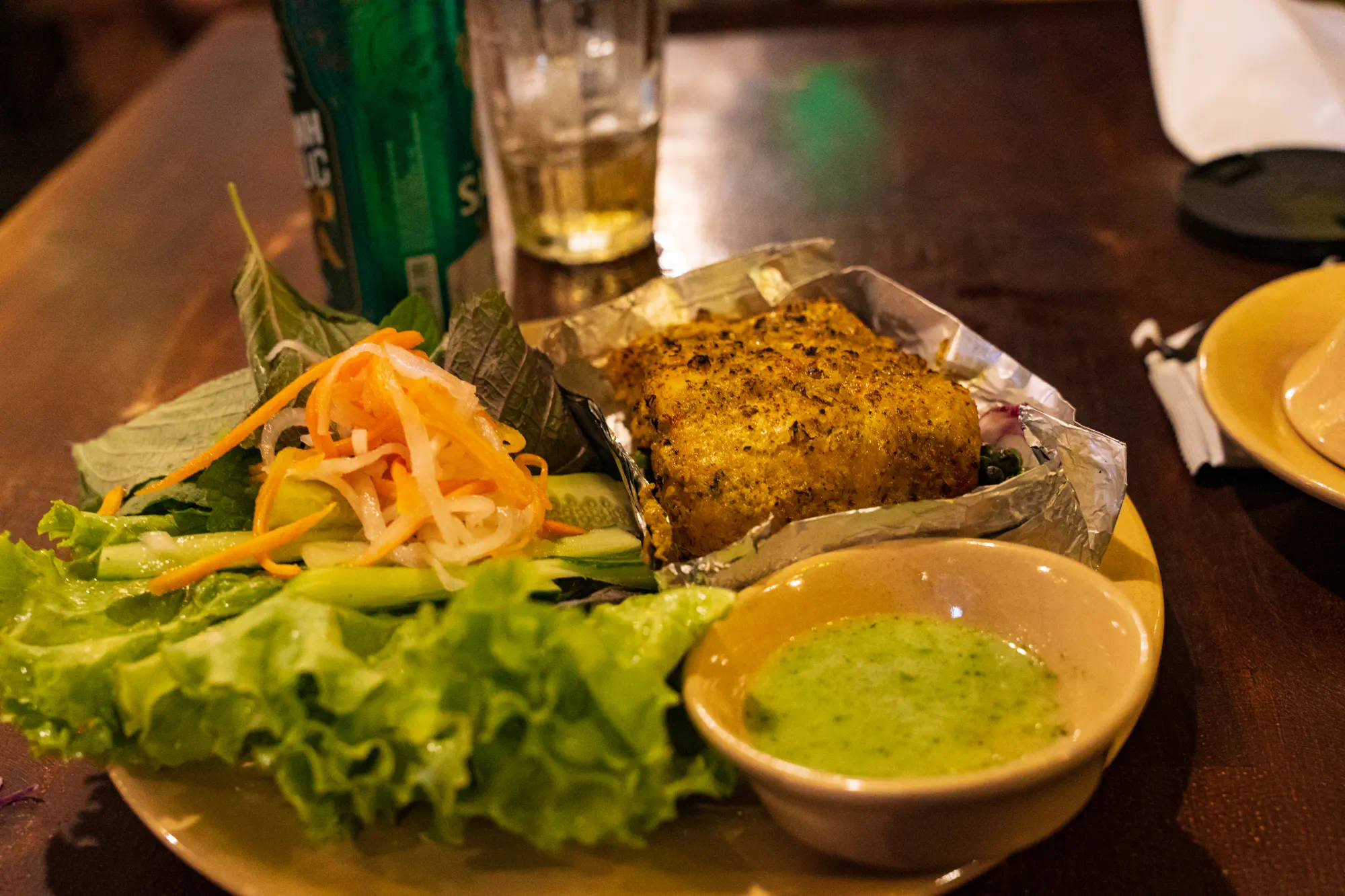 魚のグリル。たくさんの生野菜と緑のソースが添えてある